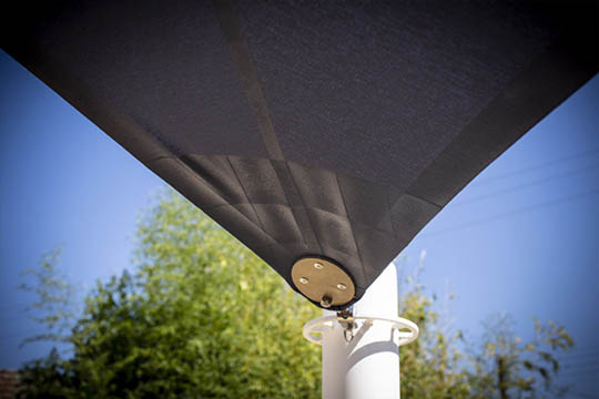 Zoom sur l'accroche d'une voile d'ombrage à un poteau noir