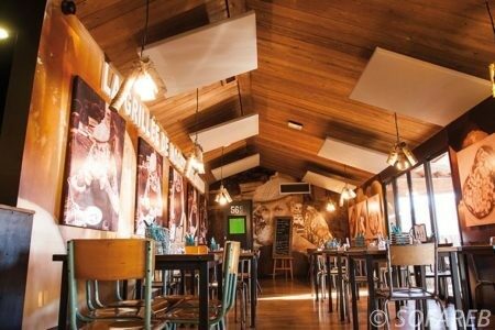 Isolation acoustique grâce à des panneaux carrés blancs dans un restaurant